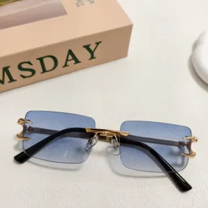 Lunettes de soleil en métal sans monture avec verres dégradés bleus et griffes dorées.