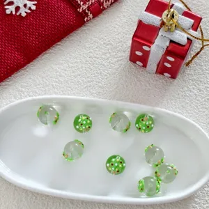 Detailed view of Christmas glass beads featuring tree pattern for DIY jewelry crafts.