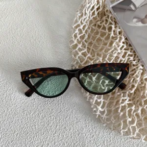 Primer plano de gafas de sol retro ojo de gato con montura carey y lentes verdes.