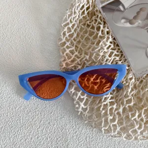 Vista de cerca detallada de gafas de sol retro ojo de gato con montura azul clara y lente naranja.
