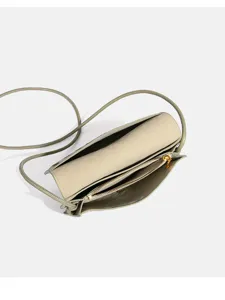 Gedetailleerd topzicht op de lichtgroene geweven leren crossbody tas met meerdere binnenvakken.