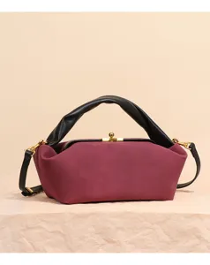 Detailansicht der burgunderroten Wildleder Kueschen-Tasche mit schwarzem gedrehtem Henkel.