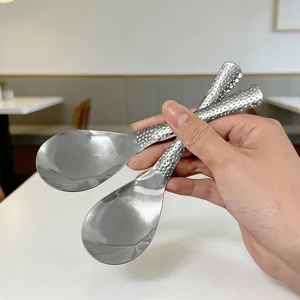 Gedetailleerd close-up van gehammerde roestvrijstalen lepel met korte steel, matte textuur.