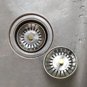 Vue detaillee du panier de filtration d'evier en acier inoxydable avec poignee doree.