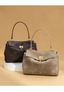 Detail view of minimalist suede tote bags showcasing exquisite metal locks and premium texture.