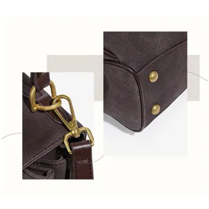 Detailed view of women brown suede shoulder handbag metal hardware and bottom feet decor.