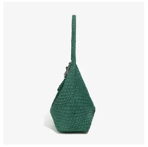 Close-up detail of green woven leather shoulder bag showcasing intricate texture and craftsmanship.