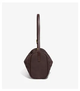 Detailed side view of dark brown woven leather cylinder bag showcasing unique texture.