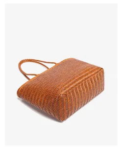 Dettaglio borsa shopper in pelle intrecciata a mano, elegante borsa a spalla marrone.