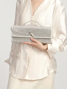 Elegant silver rhinestone evening clutch bag with top handle and metal lock detail for women.