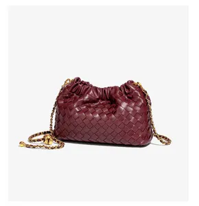 Burgundy woven leather cloud crossbody bag with gold chain strap, stylish detail view.