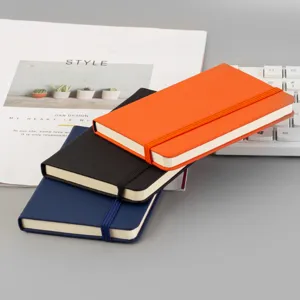 Detail carnet rigide A6, couverture en cuir PU coloree avec fermeture elastique, vue de bureau.
