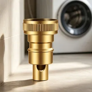 Gros plan détail de la valve de raccordement en laiton pour machine à laver, finition dorée.
