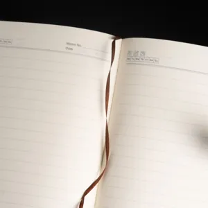 Close-up detail of open lined notebook page with ribbon bookmark, memo and date layout.