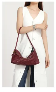 Detail view of a stylish women's burgundy woven leather hobo shoulder bag worn by a model.