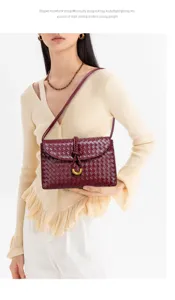 Sac bandoulière tressé pour femme, élégant sac bordeaux avec accessoires métalliques.