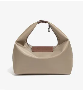 Gedetailleerd overzicht van de minimalistische nylontas met duurzame lederen flap en handvat.