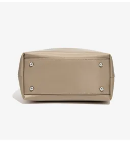 Bodemdetail van een beige nylon shopper tas met stevige metalen voetjes en versterkte.