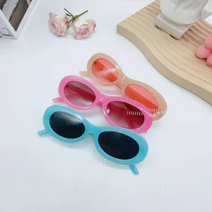 Detailed shot of trendy retro oval sunglasses in blue, pink, and nude colors with chic frames.