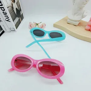 Close-up detail of trendy retro oval sunglasses in vibrant cyan and pink colors. Stylish eyewear.