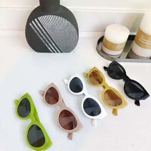 Close-up detail of trendy small frame round sunglasses in multi-colors arranged neatly on white table.