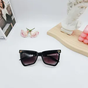 Detailansicht modischer schwarzer Cat-Eye-Sonnenbrille mit Metalldetails auf dem Tisch.