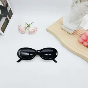 Black oval sunglasses for women, trendy vintage retro eyewear with dark lenses for stylish summer looks.