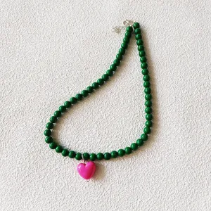 Grünes Perlenhalsband mit rosa Herzanhänger Detail zeigt feine Handwerkskunst im süßen Stil.