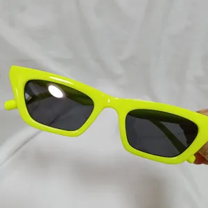 Neon green jelly sunglasses detail shot, retro street style fashion eyewear accessory.