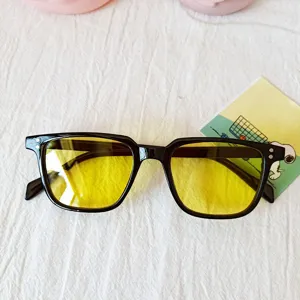Detailed view of trendy black frame sunglasses featuring vibrant yellow lenses for fashion.