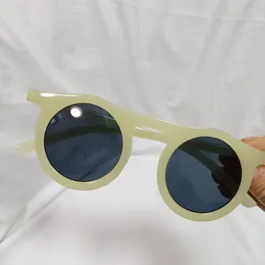Detail view of retro round jelly sunglasses in light green, fashionable summer eyewear piece.