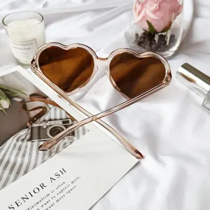 Lunettes de soleil cœur rétro avec monture rose et verres marron pour look streetwear tendance.