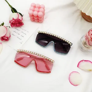 Vue détaillée de lunettes de soleil oversize sans monture avec perles et strass.