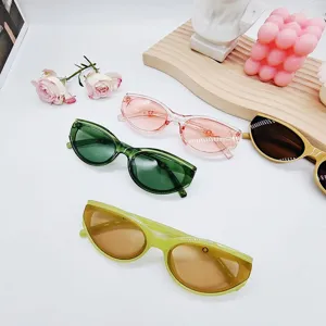 Gros plan de lunettes de soleil œil de chat colorées jelly tendance avec montures claires.