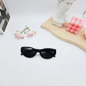 Lunettes de soleil œil de chat noires tendance avec monture étroite pour un style chic.