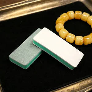 Detailed close-up of double-sided polishing sponge blocks and amber beads on a vintage tray.