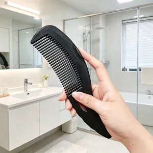 Black plastic hair comb detail view, scalp massage comb design for daily hair styling use.