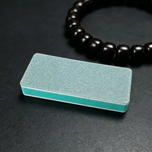 Detailed close-up view of the green sponge polishing block for jade and nail art grinding.