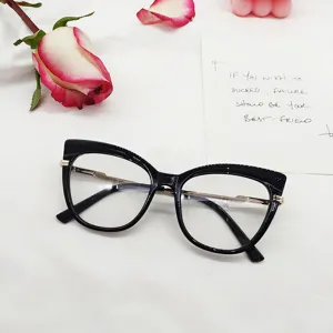 Vista detallada de la montura de gafas cat-eye negra con elegantes patillas de metal.