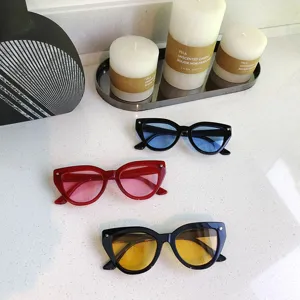 Detailed view of trendy small-frame cat-eye sunglasses with colorful lenses in various shades.