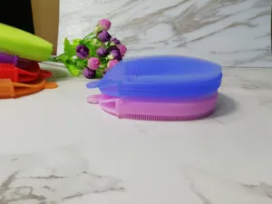 Détail de brosse de bain en silicone avec poils souples colorés et trou de suspension pour nettoyage.