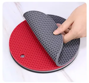 Gros plan detaille du dessous de plat en silicone souple alveole montrant texture et flexion.