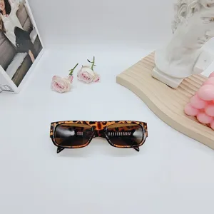 Detalle de gafas de sol retro de montura pequeña con estampado de leopardo, accesorio de moda.