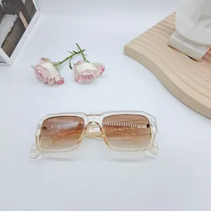 Dettaglio di occhiali da sole quadrati alla moda con montatura trasparente e sfumata.