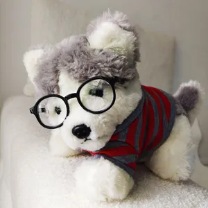 Adorable chien en peluche portant des lunettes rondes noires et des vêtements rayés.