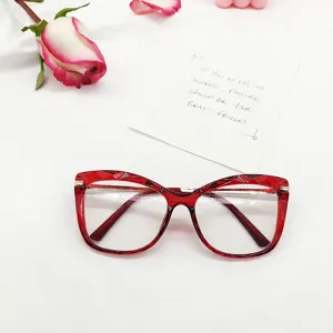 Red faceted cat-eye glasses frame detail view, stylish flat lens eyewear prop closeup.
