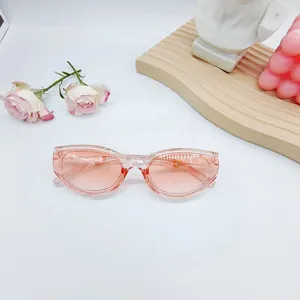 Détail de lunettes de soleil œil-de-chat jelly rose avec monture transparente estivale.