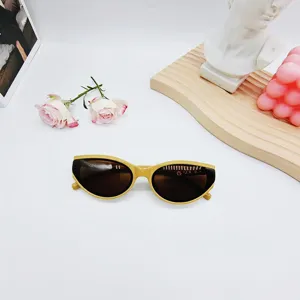 Gros plan detail de lunettes de soleil tendance œil de chat jaunes avec accessoires.