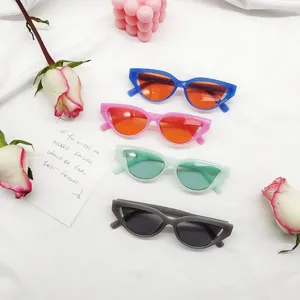 Retro cat eye sunglasses detail view, colorful lenses, trendy hip-hop eyewear on white cloth.