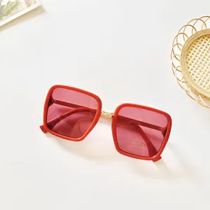 Detailed view of fashionable square sunglasses with red frame and pink UV400 lenses.